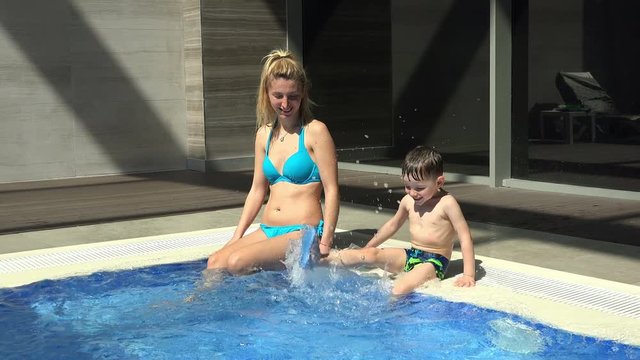 Cute baby boy enjoying with his mother in the swimming pool