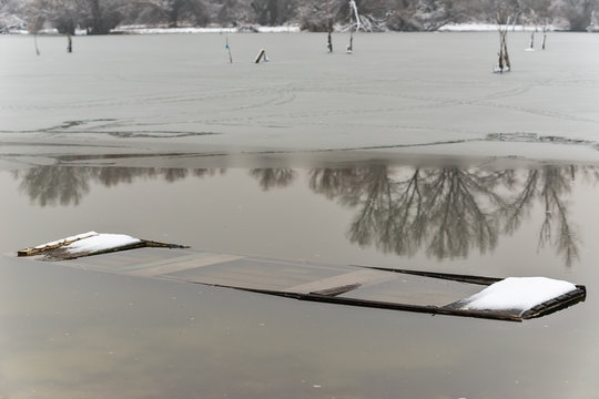 Danube island (&Scaron;odro&scaron;) near Novi Sad, Serbia. Colorful landscape with snowy trees, beautiful frozen river. A boats covered with snow or submerged.