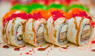 Closeup of chef hands preparing japanese food. Japanese chef making sushi at restaurant. Young chef serving traditional japanese sushi served on a black stone plate.