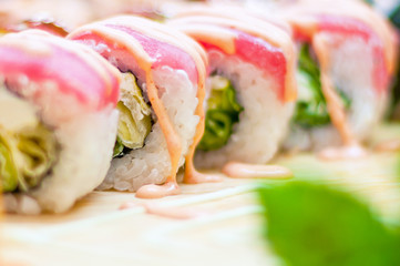Closeup of chef hands preparing japanese food. Japanese chef making sushi at restaurant. Young chef serving traditional japanese sushi served on a black stone plate.