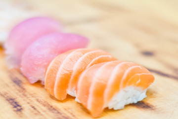 Closeup of chef hands preparing japanese food. Japanese chef making sushi at restaurant. Young chef serving traditional japanese sushi served on a black stone plate.