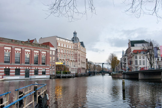 View of the south of canal with Halvemaansbrug bridge in Amsterdam, Netherlands.