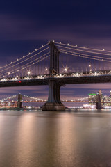 Fototapeta premium View on Manhattan bridge and Brooklyn bridge form east river at night with long exposure 