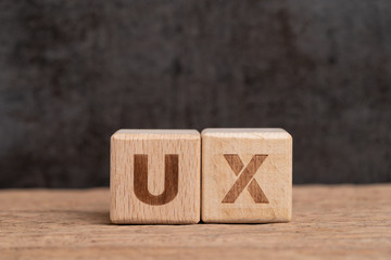 UX User Experience design in product and service concept, cube wooden block building acronym UX on...
