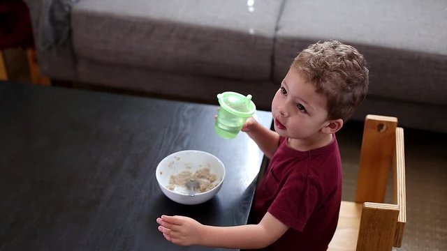 Little boy drinking water eating breakfast