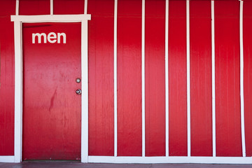 Red paint and white stripes on the men's restroom.