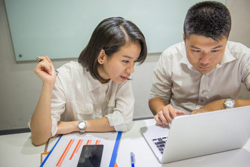 Two Asian office employees working in a team