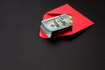 Dollar money in the red envelope on black background bonus, reward, benefits concept.