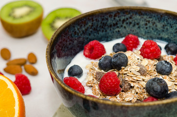 Yoghurt with cereal, berries and raisins. Healthy breakfast on the table 