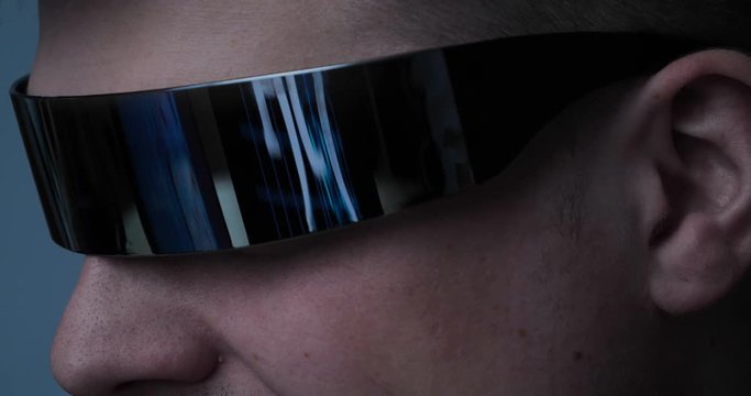 The guy (male) gamer in a tracksuit and game glasses. In the reflection you can see the game guy completely immersed. Concept of: 3D, Fully immersed in the game, Reflections, Dependence.