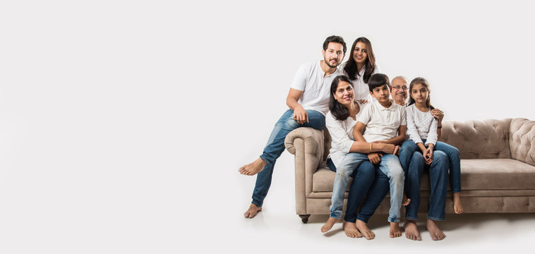 Indian/asian Family Sitting On Sofa Or Couch Over White Background