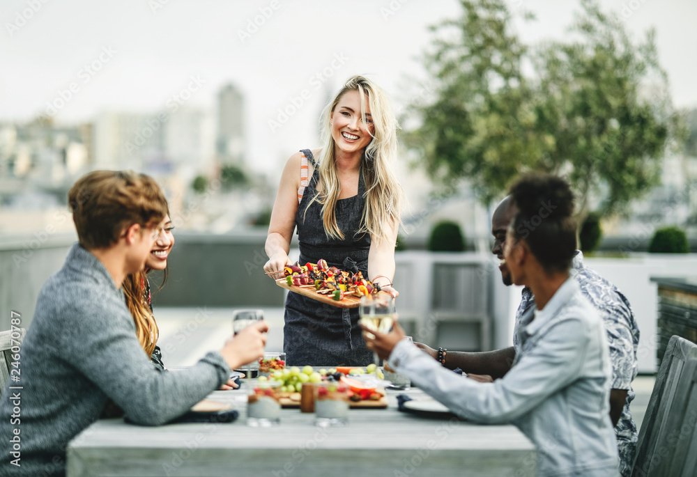 Wall mural Woman serving vegan barbecue to her friends