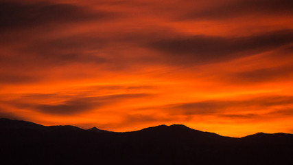 Red and Orange Sunset with Mountain Silhouette and Clouds