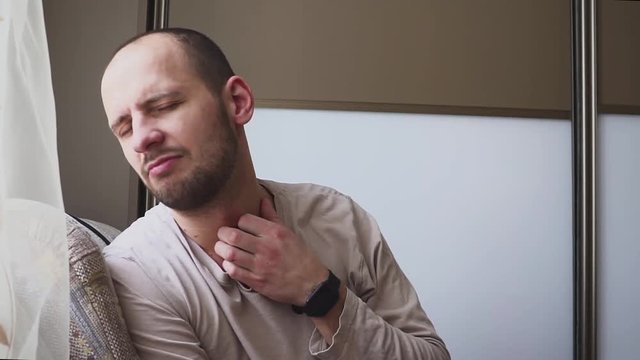 Allergies to the neck and shoulders. Man with psoriasis is touching his dry, itchy, and scaly skin on neck.