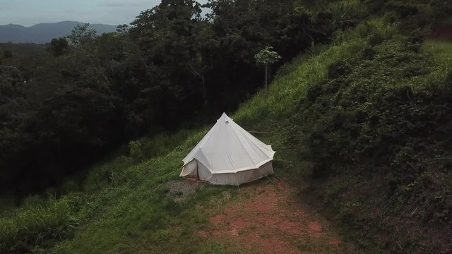 AERIAL: panning across an old style bathroom and pitched tent on the mountain tops of Utuado, Puerto Rico.