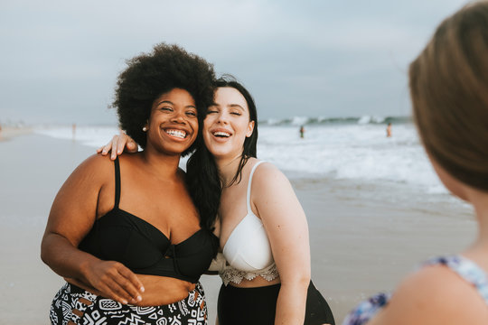 Cheerful beautiful plus size women at the beach