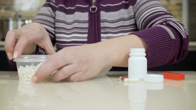 Woman eating diet cheese before drinking medcine pills. Strict medical diet. Health problems. Digestive Disorders and Gastrointestinal Diseases
