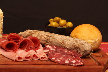 Food tray with delicious salami, pieces of sliced ham and chesses