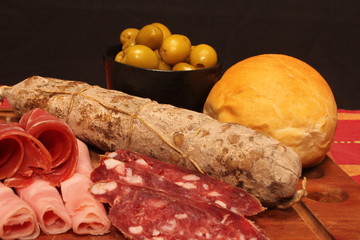 Food tray with delicious salami, pieces of sliced ham and chesses