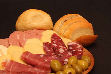 Food tray with delicious salami, pieces of sliced ham and chesses