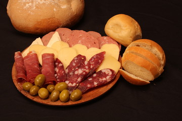Food tray with delicious salami, pieces of sliced ham and chesses