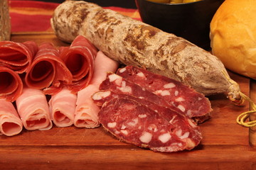 Food tray with delicious salami, pieces of sliced ham and chesses