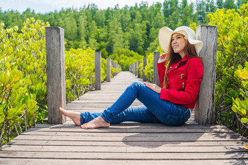 woman wearing red clothes in wooden bridge at Tung Prong Thong or Golden Mangrove Field, Rayong, Thailand