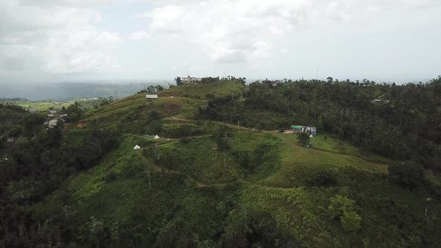 AERIAL: wide push in towards some housing on the mountain tops of Utuado, Puerto Rico.