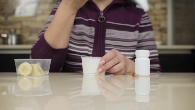 Woman eating yoghurt. Strict medical diet. Pills. Digestive disorders disease