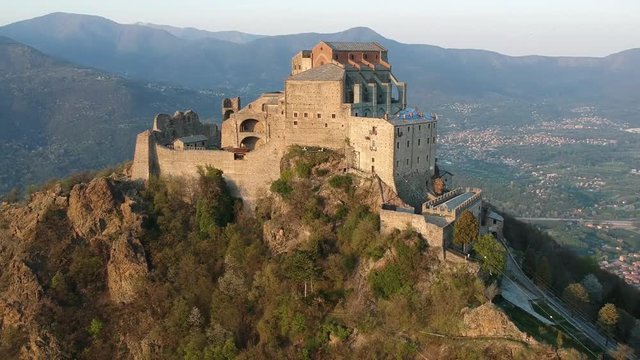 The Sacra di San Michele (Saint Michael's) Abbey, Turin, Italy, sunset shot aerial with mountains of Susa valley in background. Aerial view