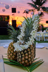 Pineapple on table at Luau and Hawaiian Lei at sunset Hawaii