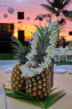 Pineapple On Table At Luau And Hawaiian Lei At Sunset Hawaii