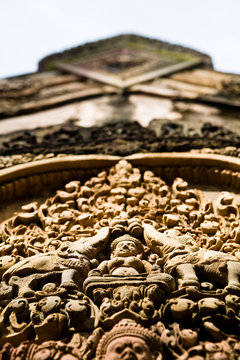 Carvings of Buddha, elephants, demons and ornamental patterns at visit Banteay Srei temple.