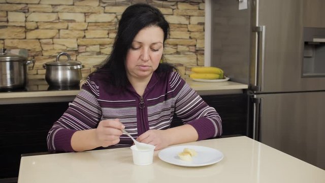 Woman eating unappetizing yoghurt. Strict medical diet. Health problem