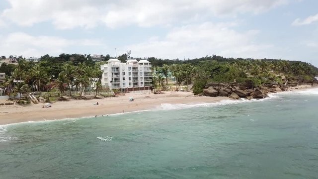 AERIAL: quick wrap around and pull away from Sandy Beach in Rincon, Puerto Rico on a beautiful day.
