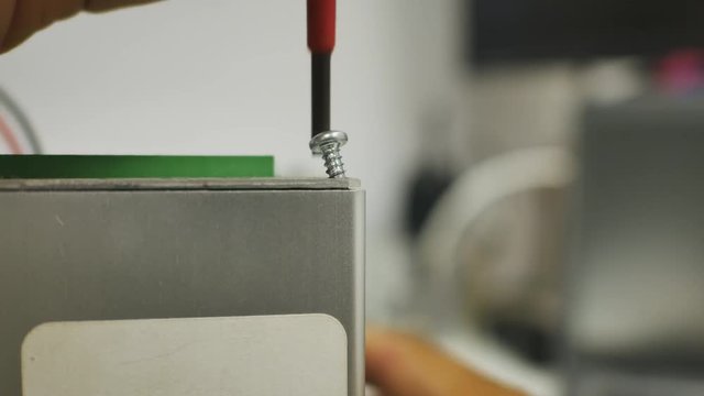 Close up of a man to tighten screw to aluminum box