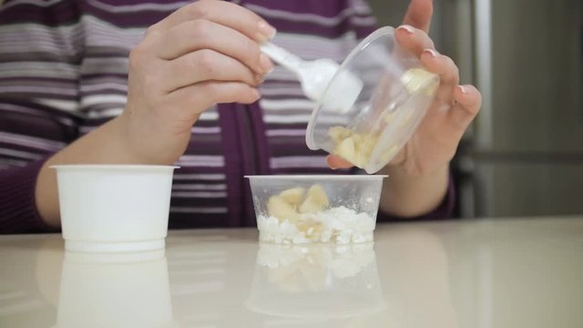 Woman mixes diet cheese, bananas and yogurt before eating. Strict medical diet