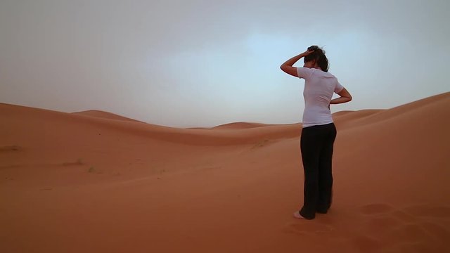 Handsome girl brunette lost in the very windy desert of sahara 