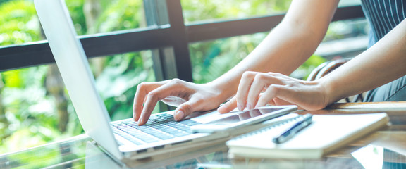 Business woman hand working with a laptop computer in the office.