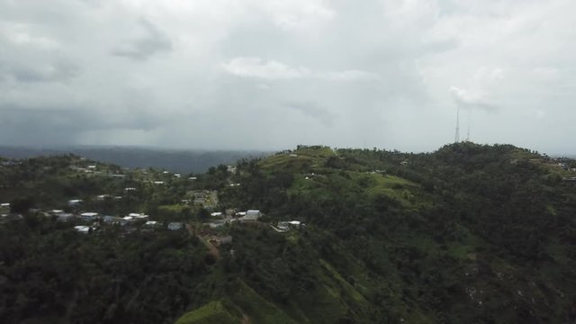 AERIAL: extreme wide pull away and tilt down between the mountain tops of Utuado, Puerto Rico.