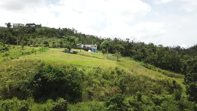 AERIAL: pulling away from a flattened camping ground on the mountain tops of Utuado, Puerto Rico.