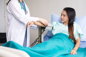 Obraz premium Doctor woman checking to her asian patient blood pressure in hospital,Heart rate pressure gauge