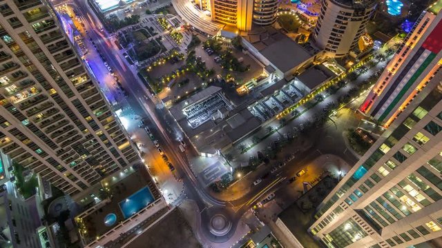 Aerial view of modern illuminated skyscrapers and beach at Jumeirah Beach Residence (JBR) night timelapse in Dubai, UAE. Traffic on streets