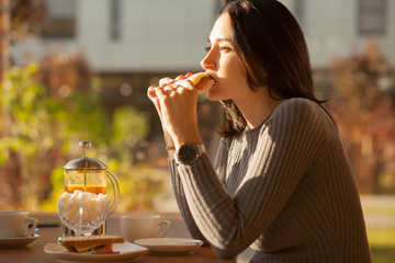 pregnant girl eating sandwich at restaurant