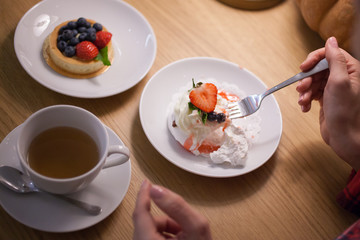 Woman eating cake at dessert cafe
