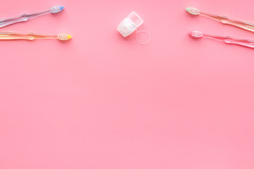 Oral hygiene. Plastic toothbrushes on pink background top view copy space