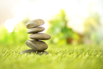 balance  with pyramid of stone on fresh nature green grass  , spa meditation or well-being with zen concept