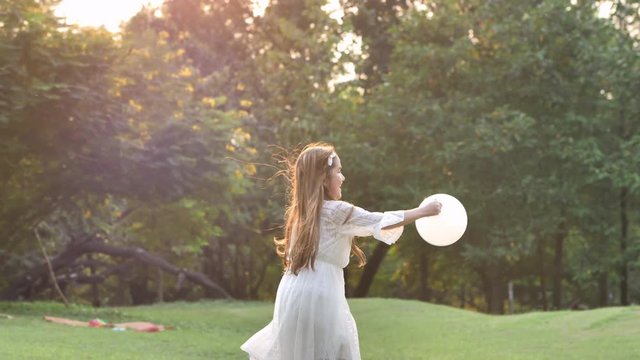 Happy little girl having fun enjoying running playing fun with balloons in a park on a sunny day. healthy life, lifestyle concept. Slow Motion