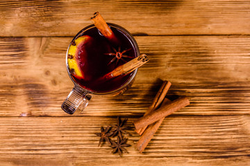 Cup of mulled wine with cinnamon on wooden table. Top view