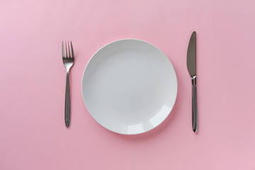 Clean white ceramic plate with knife and fork - obrazy, fototapety, plakaty